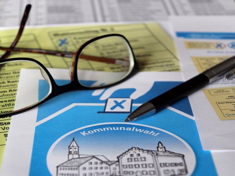 Stimmzettel, Brille und Kugelschreiber symbolisieren die Kommunalwahl