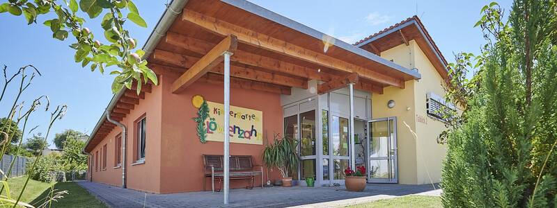 Gebäude des Kindergartens Löwenzahn in Neufra, Seitenansicht mit Ausschnitt des Außengeländes und Sträuchern