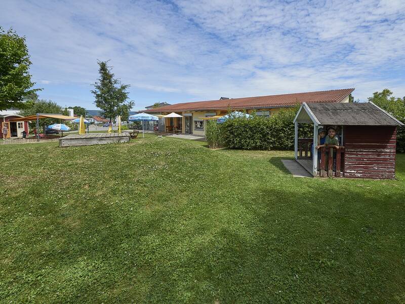 Außengelände mit Hütte und Spielgeräten des Kindergartens Löwenzahn