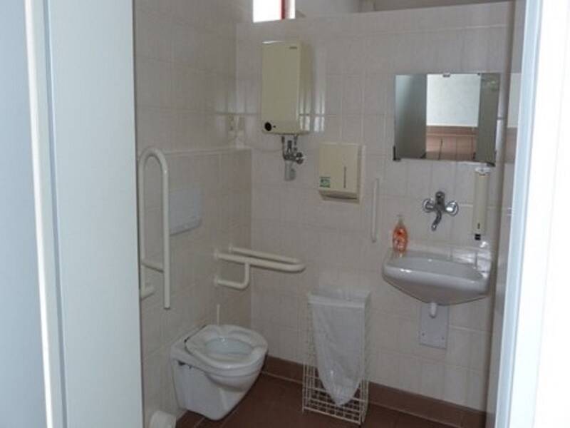 Sanitäre Anlage in der Stadthalle mit Toilette, weiß gekachelt