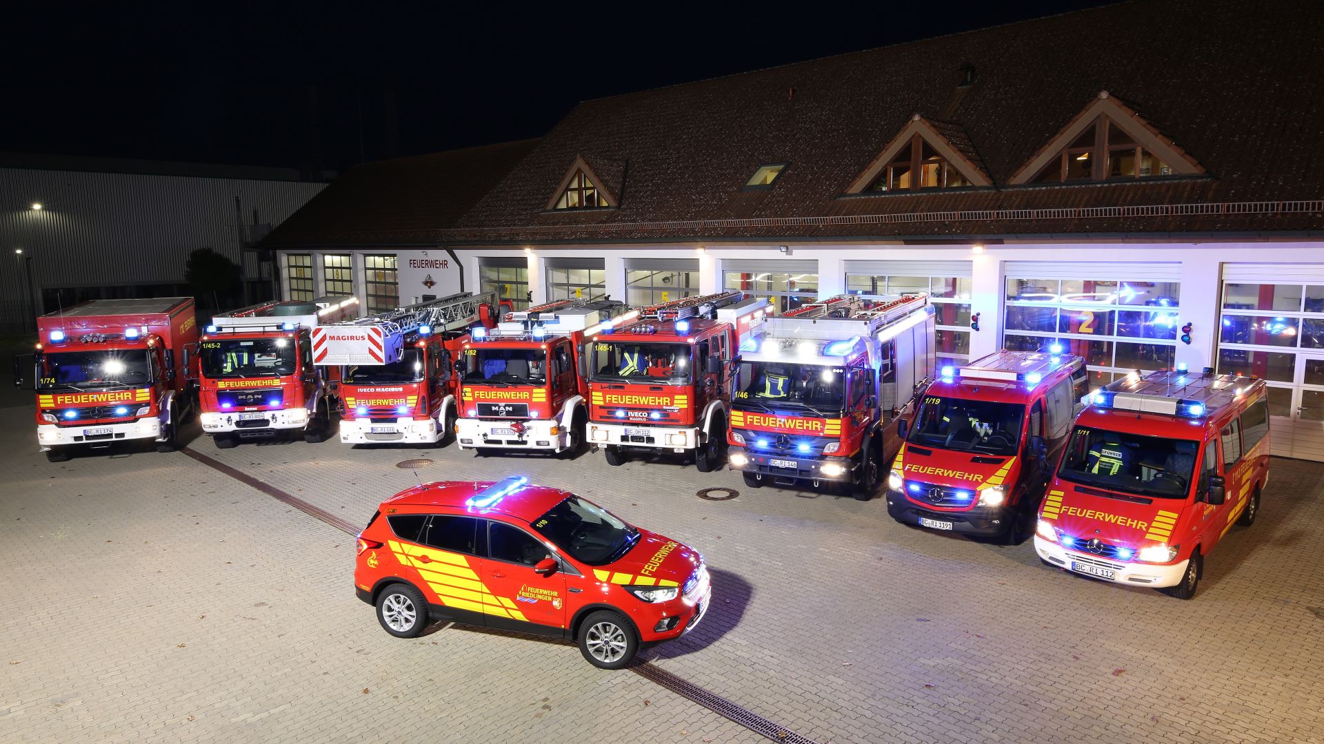 Feuerwehrfuhrpark bei Nacht vor dem Feuerwehrhaus